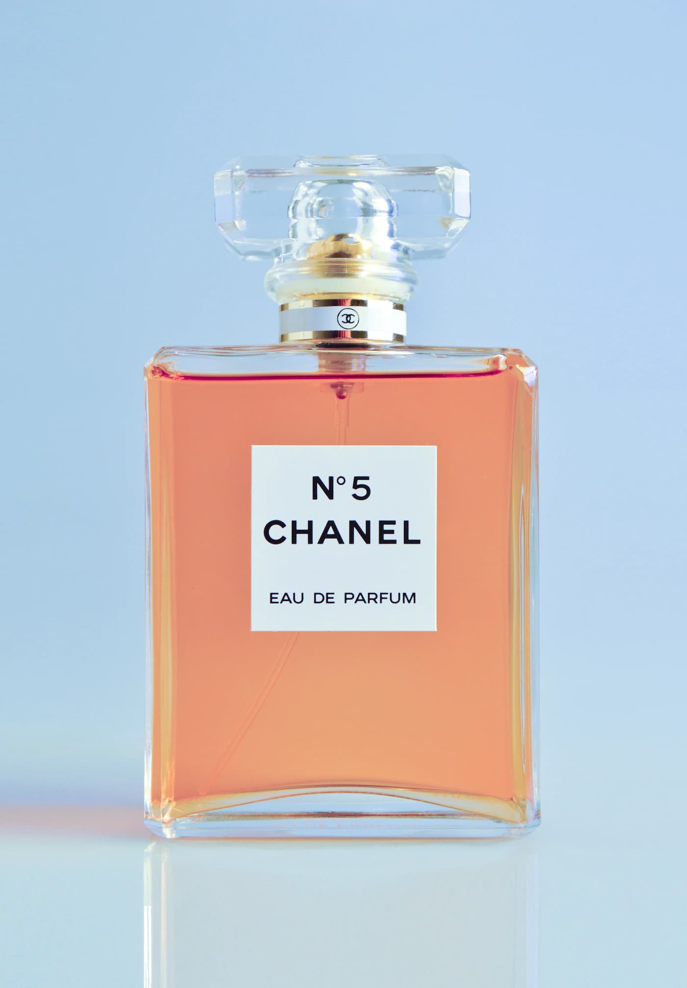 Perfume bottle and glassware in warm, moody light