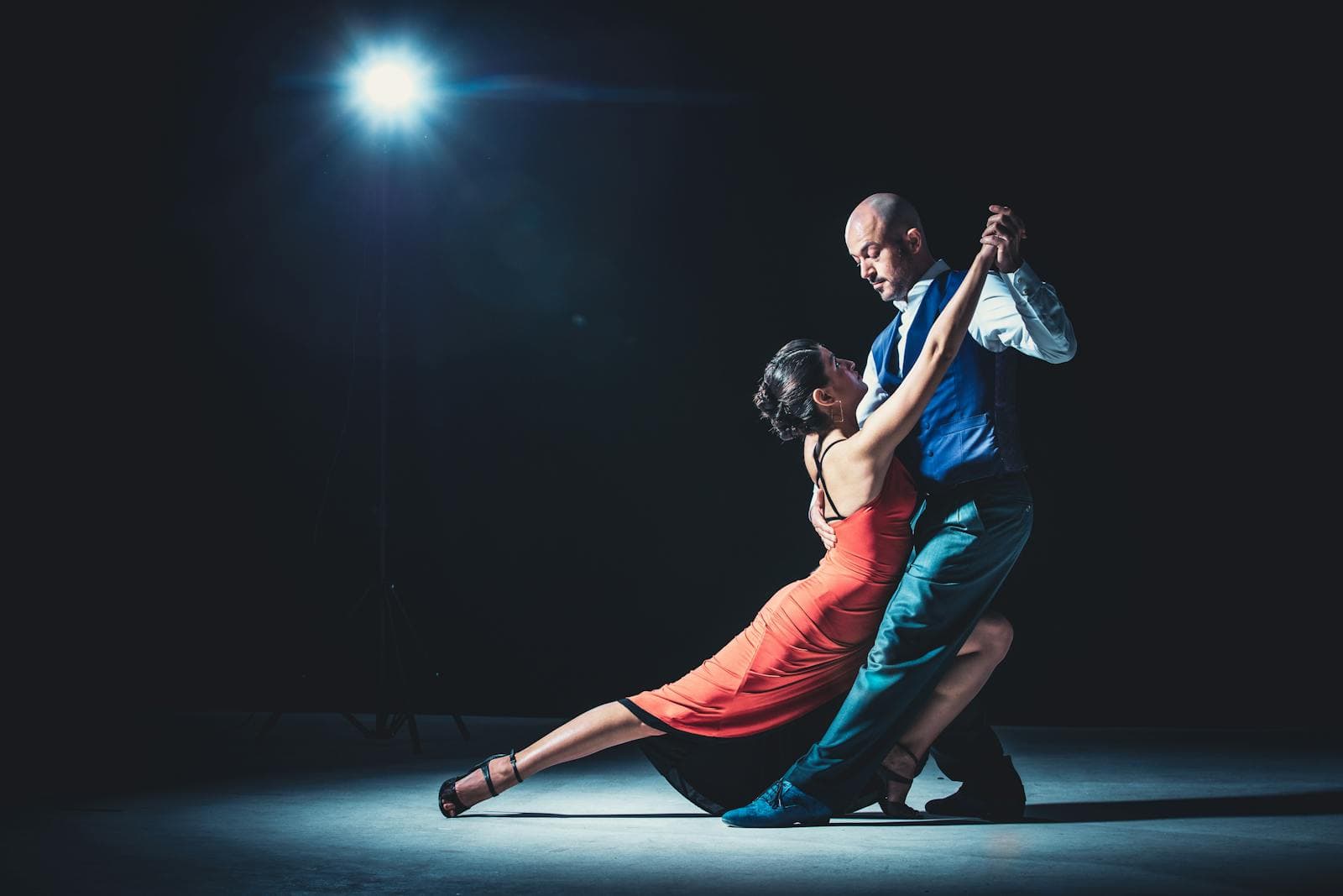 Couple dancing beneath warm chandeliers at an evening celebration